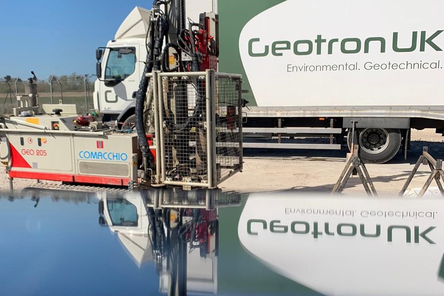 Geotron Comacchio GEO205 tracked rotary rig reflected beside a company lorry
